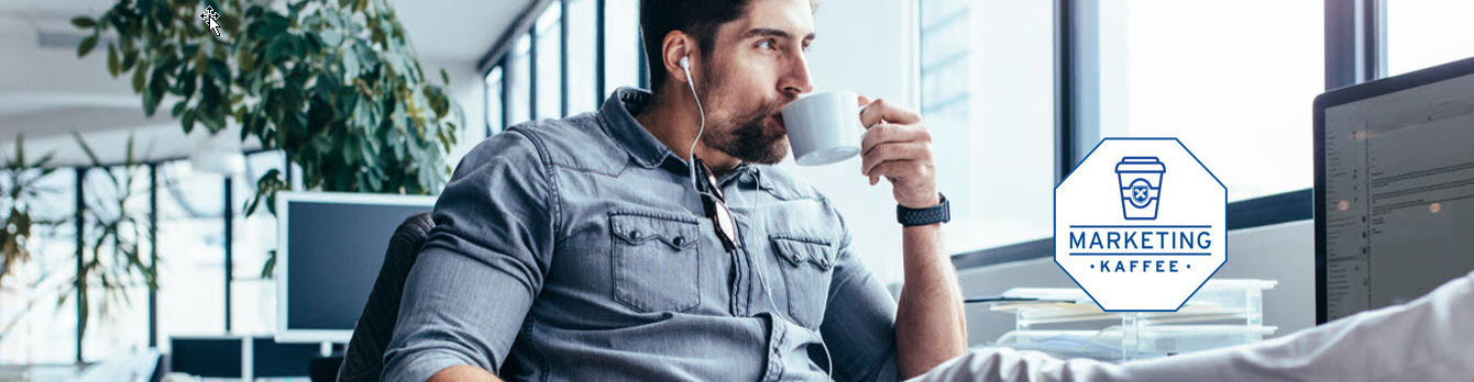 Ein arbeitender Mann legt die Beine hoch und trinkt Kaffee.