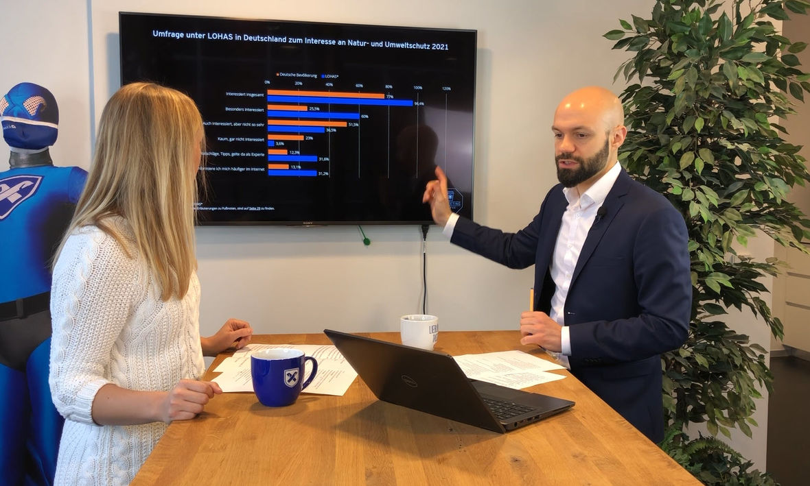 Zwei Concordia Mitarbeiter stehen an einem Tisch und schauen sich Statistiken an.